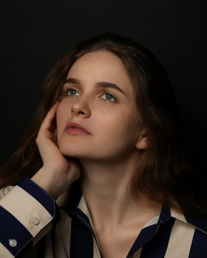 Kate Zotova portrait in Cupertino, California Portrait of Kate Zotova with her hand on her face against a dark background in Cupertino, California